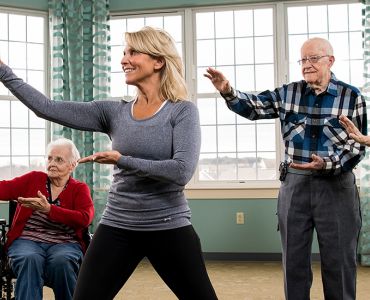 Blog11 - Woman guides group of seniors in dance activity