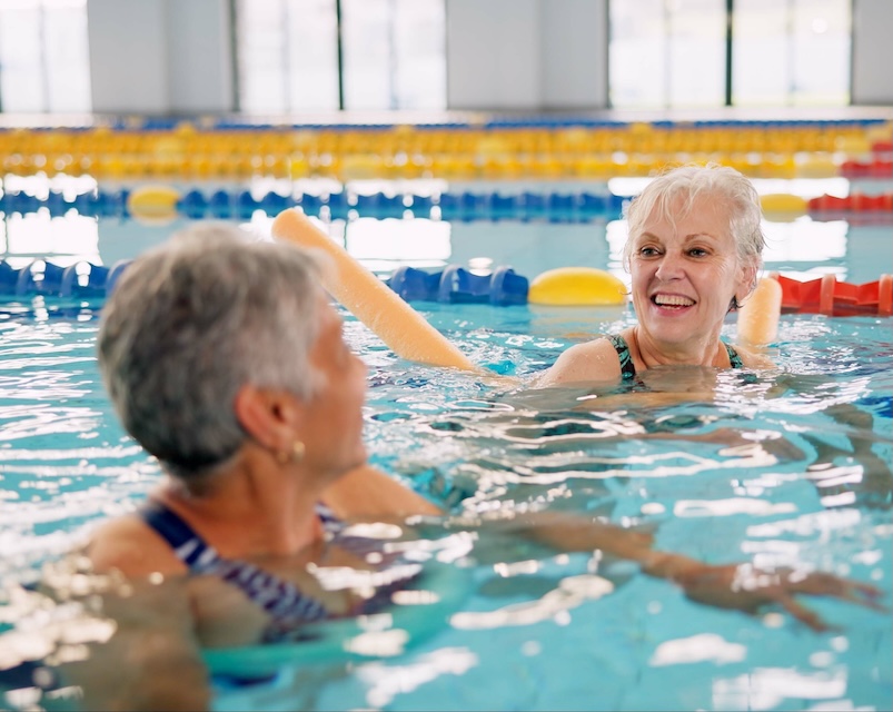 Smiling senior women swimming in an indoor pool