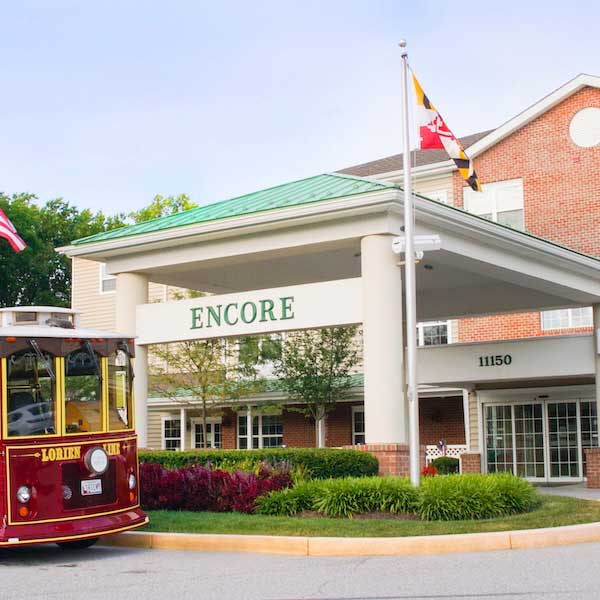 Red trolley parked outside the Encore building entrance at Lorien Encore
