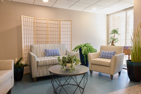 Sitting area with sofa, armchairs and plants at Lorien Harmony Hall
