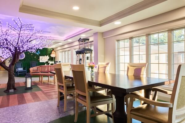 Dining area with a purple-blossom decorative tree and large windows at Lorien Harmony Park