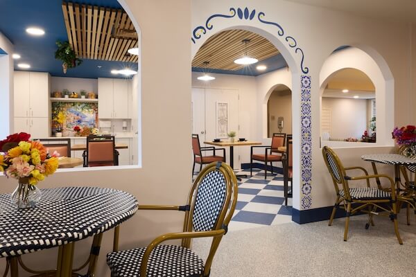 Café seating with arched doorways and fresh flowers at Lorien Harmony Park