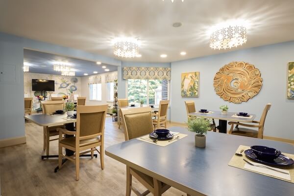 Dining room with blue tables and decorative wall art at Lorien Harmony Park